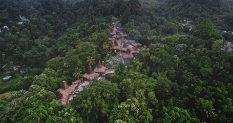 Aerial view capturing a traditional village with typical houses nestled among the lush tropical vegetation of Sumba island, Indonesia, showcasing cultural heritage and natural beauty