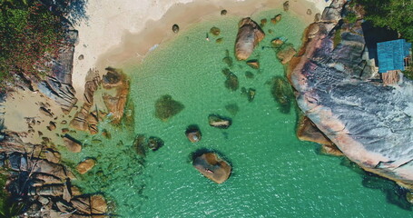 Aerial view of a beautiful tropical beach with crystal clear turquoise water, rocks, white sand,...