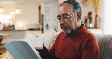 Coffee, tablet and senior man with living room, sofa and reading online news blog post. Relax,...