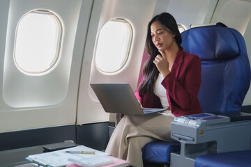Businesswoman working on laptop during flight in first class