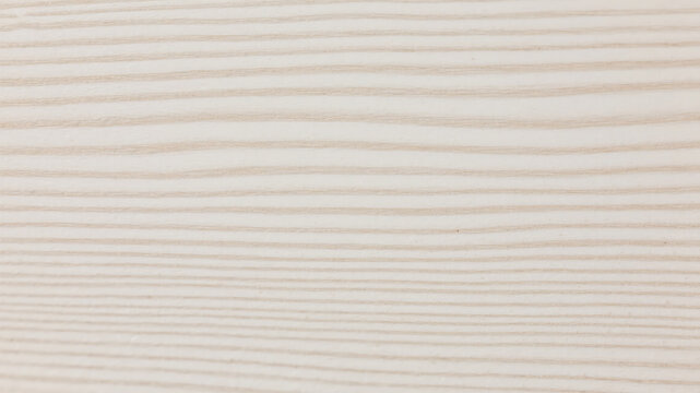 Close up of wood grain texture showcasing natural light brown and beige tones in parallel lines.