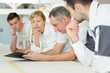 Fototapeta premium row of pensive students on decorating course