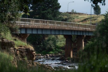 Scenic bridge over a tranquil river surrounded by lush greenery.