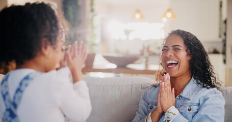 Games, mother and girl with hands together, home and playing with fun, break and bonding in lounge. Family, apartment and parent on couch, mama and daughter with motor skills, funny and happiness