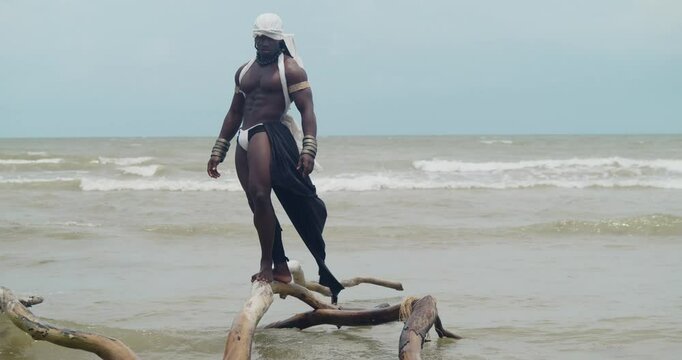 A dark-skinned male cosplayer with muscles on the beach.