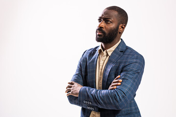 Portrait of worried and thoughtful businessman. Black man in business suit is standing with arms crossed and thinking.