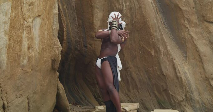 With muscles and dark skin, a male cosplayer enjoys the beach.