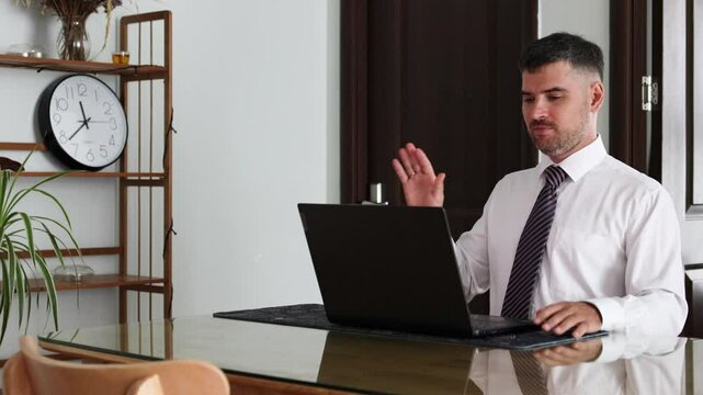 Man adjusts his tie before a video conference.