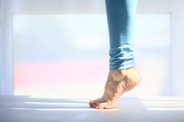 The girl is standing on her toes, legs in close-up