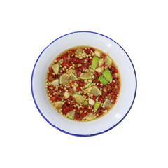 Top view of Thai spicy dipping sauce with chopped chilies, garlic, and lime in a white enamel bowl....