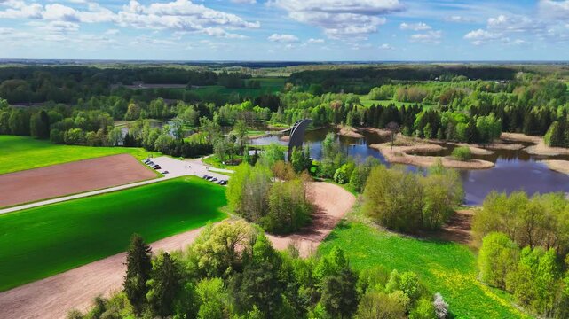 A Stunning View Unfolds From the Kirkilai Observation Tower, Revealing Winding Boardwalks, Serene Karst Lakes, and Lush Forested Surroundings in Biržai Regional Park, Lithuania - Orbit Drone Shot