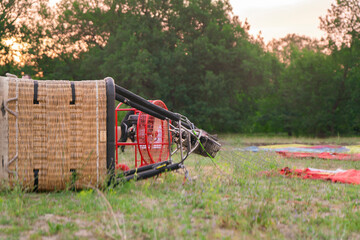 Aerostat balloon basket is positioned on the ground as crew members prepare it for an upcoming...