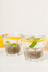 Healthy breakfast or morning with chia seeds lemon and mint on table background, vegetarian food, diet and health concept. Chia pudding with lemon and mint