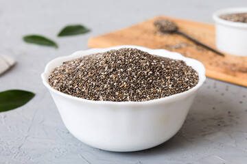 Chia seeds in bowl and spoon on colored background. Healthy Salvia hispanica in small bowl. Healthy superfood