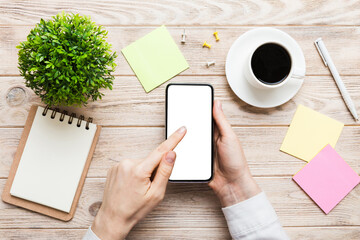 Obraz premium Top view of woman hands holding smart phone with blank copy space screen for your text message or information content. woman hand using phone white screen on top view