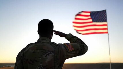 A soldier in camouflage uniform stands at attention, saluting the American flag as it waves against a sunset or sunrise sky, symbolizing patriotism, duty, and respect for the country. - Powered by Adobe