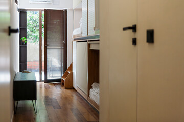 Modern hostel with cozy minimalist dorms, wooden capsule beds, and peaceful courtyard. Men chatting and relaxing in a quiet neighbourhood