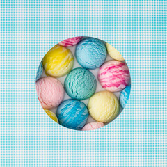 Creative summer composition with colorful ice cream scoops visible through a circle shaped gap on white and blue background. Sweet food concept. Trendy yummy dessert idea. Flat lay style. Top view.