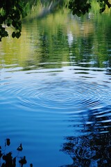 Naklejka premium Ripples on a calm pond reflecting trees