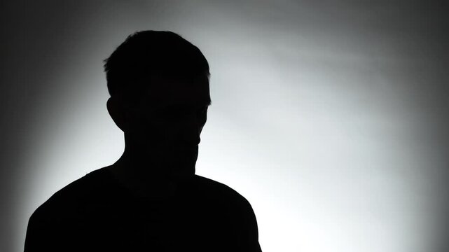 Anonymous interview with a man in a dark studio. Male silhouette.