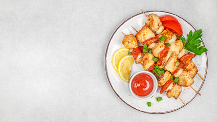 Chicken kebab with tomato sauce and herbs on a wooden background. Top view with copy space