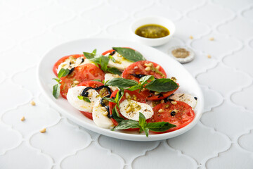 Traditional Caprese salad with pesto sauce