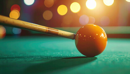 A billiard cue hitting a ball on a pool table with bright, blurred lights in the background