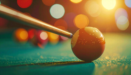 Billiard cue poised to strike an orange ball on a green felt surface, blurred lights behind