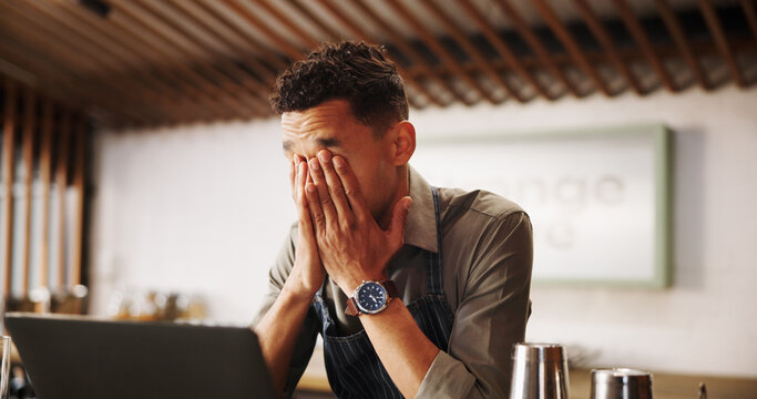 Frustrated man, barista and laptop with mistake for fatigue, eye strain or company bankruptcy at restaurant. Male person, bartender or overworked on computer for fail, loss or debt at indoor bar