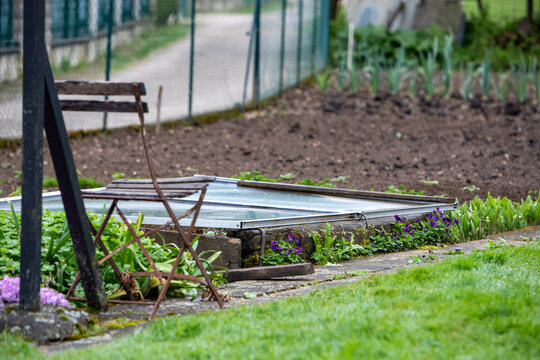 Couche chaude enterr&eacute;e dans un potager au printemps. Une chaise est au premier plan, un jardin potager en pr&eacute;paration en arri&egrave;re plan.