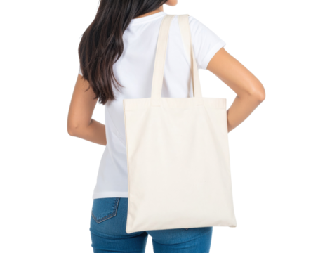 A woman carries a plain canvas tote bag over her shoulder, wearing a white t-shirt and blue jeans.