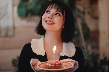 birthday cake with one candle, a girl makes a wish on her birthday