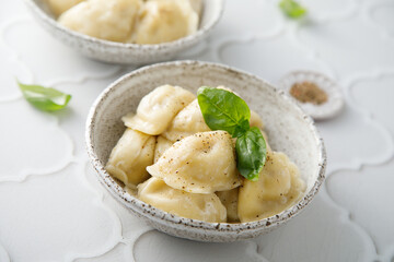 Homemade dumplings served with fresh basil
