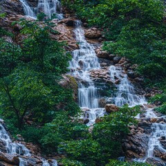 Exotic waterfall flowing through dense jungle surrounded by lush tropical vegetation