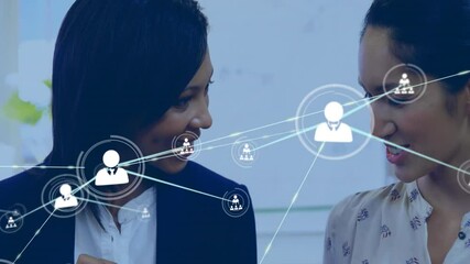 Two colleagues discussing data visualization in business meeting, showing floating network icons - Powered by Adobe