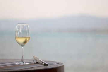 glass of cold white wine on the summer seashore by the water, relaxing by the water, a gentle background of soft color