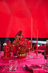 red flowers and candles on the banquet table in the dark.