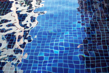 Water surface with waves on water surface wave effect, can see the blue square tiles at the bottom of the pool.