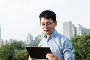 asian businessman working with digital tablet in city