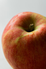 A close-up image of a fresh red and green apple with a smooth surface on a white background.