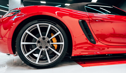 Interior of modern car workshop for vehicle polishing and detailing service. Brightly lit workspace with large led lights. High quality car valeting concept.