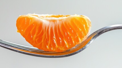 A close-up of a clementine segment being lifted by a fork