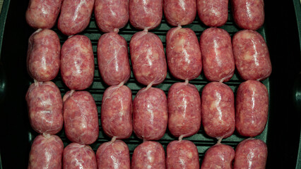 Raw Sausages Background on a Frying Pan. Process of Preparing Tasty Hotdogs. Unhealthy Food. Meat for Grill Barbeque