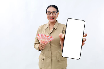 Pretty young asian teacher holding Indonesian banknotes while showing blank cell phone display