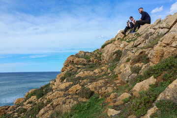 Two people walking through the landscape of the Costa Quebrada in Cantabria