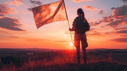 Woman in military uniform holding a flag against a sunset landscape.