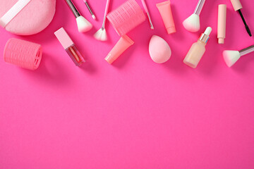 Flat lay makeup tools and cosmetics on pink surface. Beauty and glamour concept.