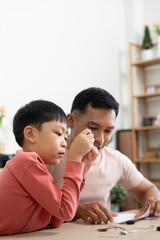Activity of father and child assembling science kits at home