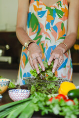 Woman preparing a fresh vegetable salad with lime dressing on a jungle veranda in Sri Lanka. Tropical lifestyle, healthy eating, and colourful ingredients in natural surroundings
