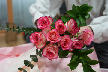 girl makes a bouquet of pink roses